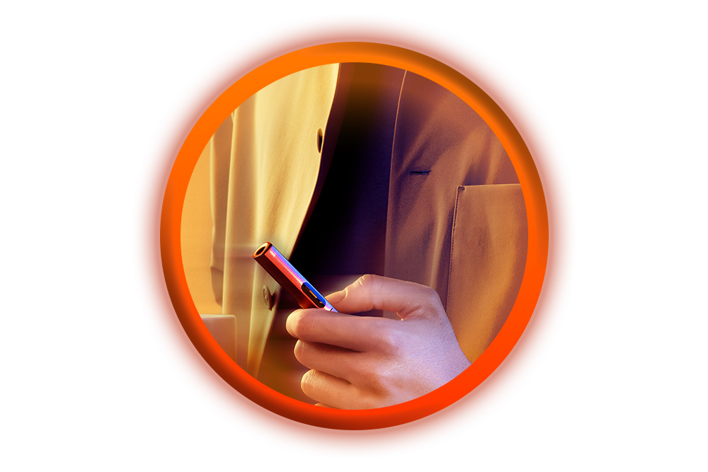 A hand holding a vape pen is seen in close-up, with the person wearing a tan coat. The image is framed by a glowing orange-red circular border on a white background.