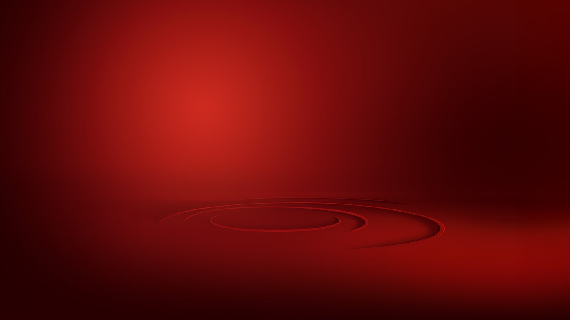 A smooth red background with subtle gradient lighting and faint circular patterns near the center, creating a minimalistic and elegant abstract design.
