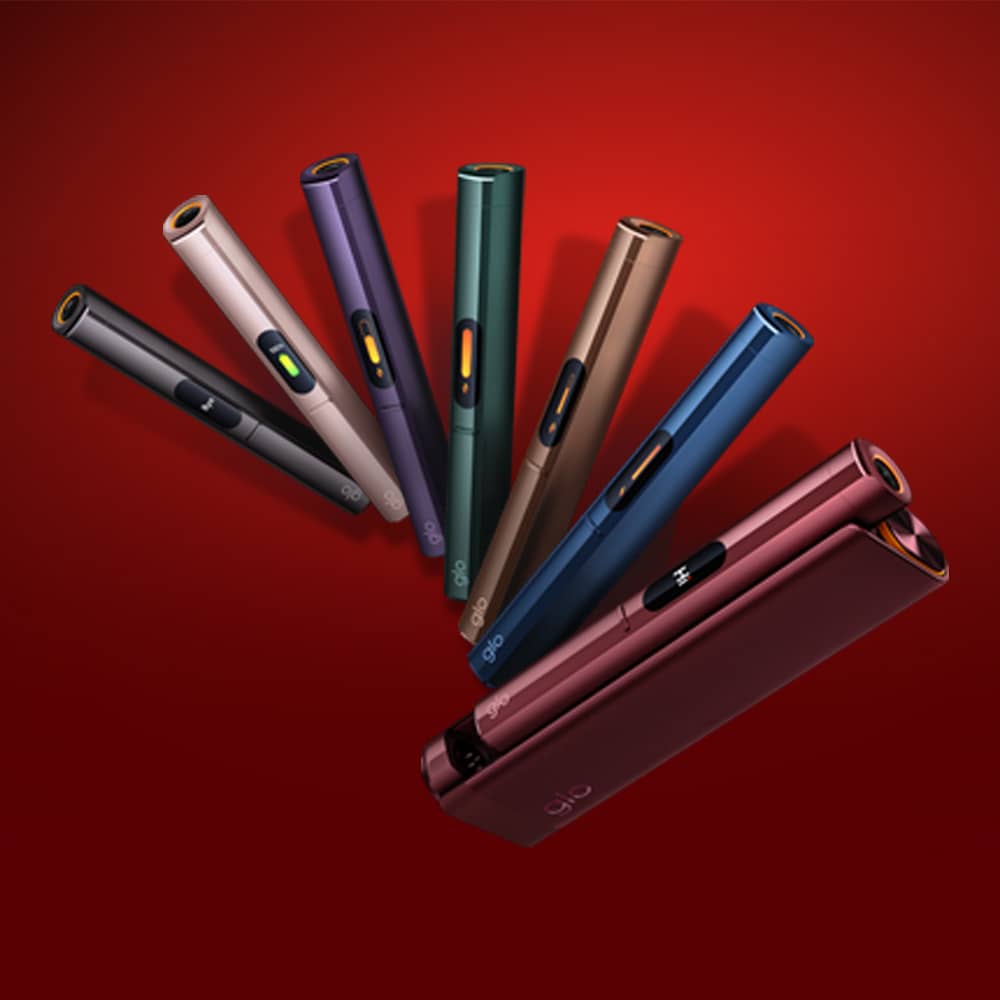 Seven slim electronic devices in different colors, arranged in a fan shape on a red background, with one device lying flat in the foreground.