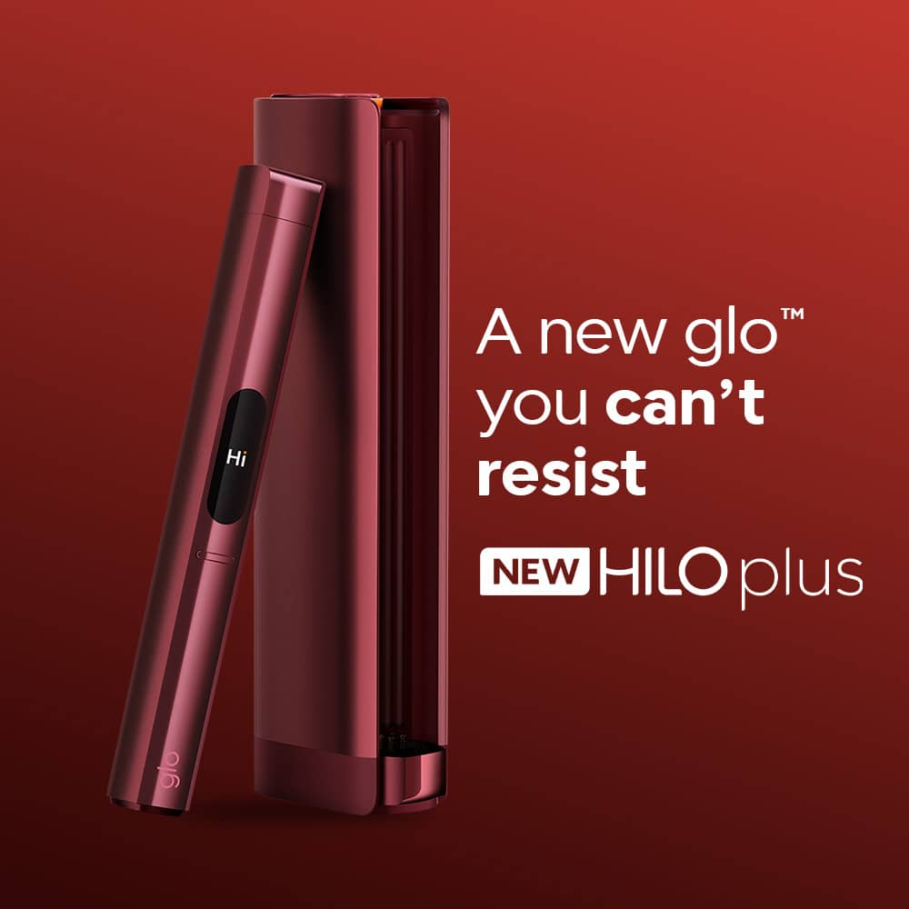 A sleek, metallic red glo™ HILO Plus stands upright beside its matching open charging case on a red background. Text reads: A new glo you can't resist. NEW HILO Plus.