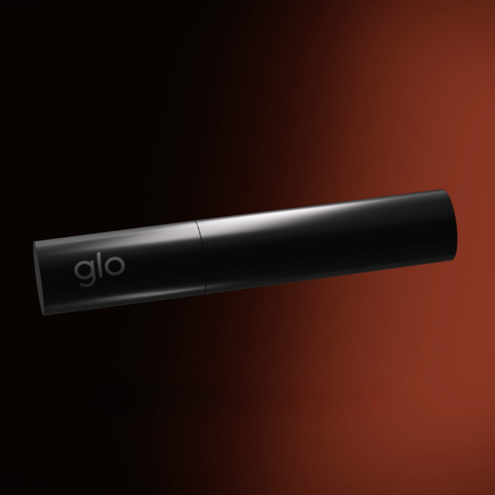 A sleek black cylindrical product labeled glo™ HILO Stick Remover rests on a dark gradient background with a reddish-brown glow, emphasizing its innovative heating chamber.