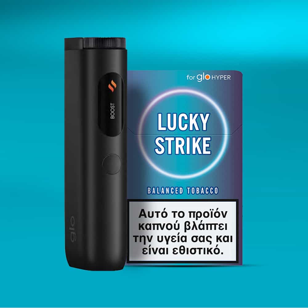 A black Glo Hyper device stands next to a Lucky Strike Balanced Tobacco pack against a blue background. A Greek health warning highlights the risks of this warm, tobacco-dominant product with mid-intensity.