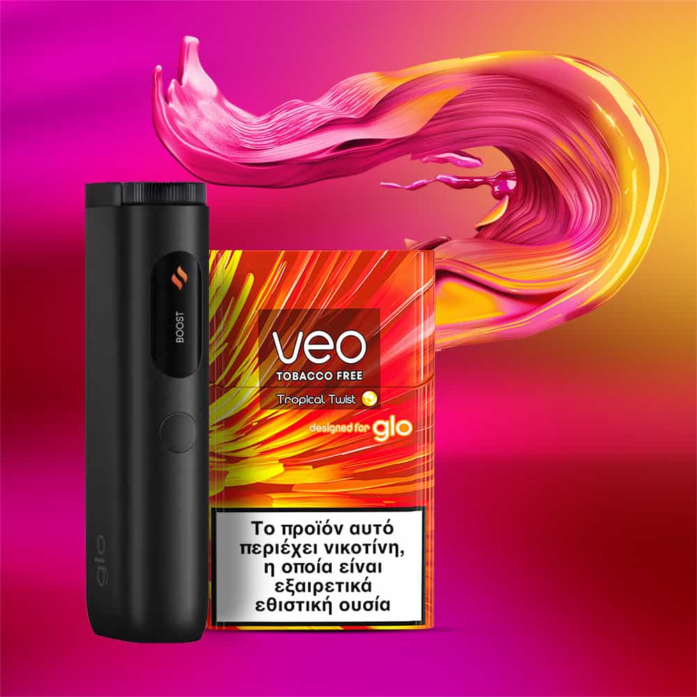 A black electronic device stands next to a colorful veo™ Tropical Twist tobacco-free product box with Greek text. Behind them, vibrant pink and yellow liquid swirls over an orange and magenta gradient background.