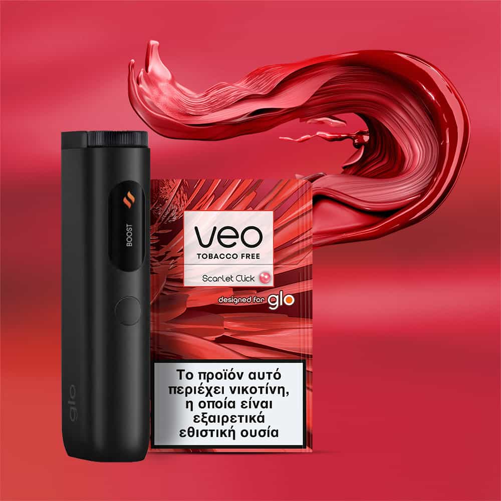 A veo™ Scarlet Click black vaping device stands beside a red and white VEO tobacco-free cartridge pack with Greek text, set against a vibrant red background with swirling paint-like effects.