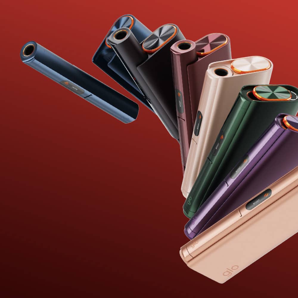 The glo™ HILO Plus features a sleek, modern cylindrical design with prominent circular buttons and comes in various metallic colors, showcased against a striking red gradient background.