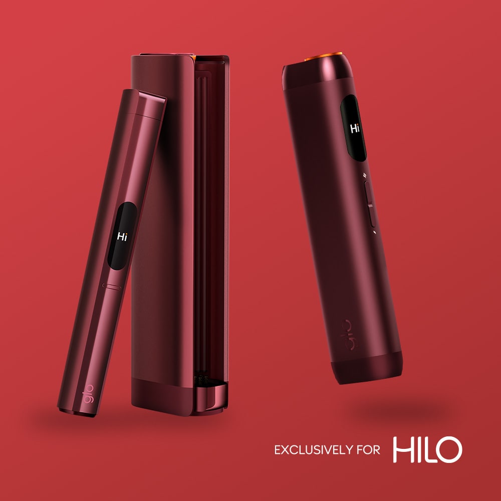 Two sleek, red rivo™ Scarlet Click devices with small screens showing "Hi" appear on a red background next to a matching rectangular case. "EXCLUSIVELY FOR HILO" is displayed in the bottom right corner.