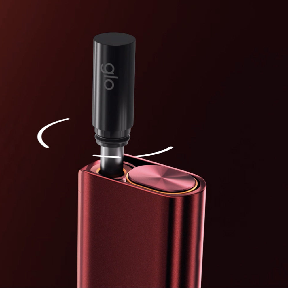 A close-up shows the metallic red glo™ HILO Stick Remover as a black cylindrical stick labeled "glo" is inserted into its heating chamber, with white arrows highlighting a twisting motion against a dark gradient background.