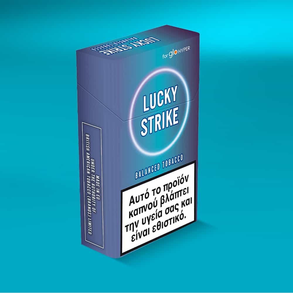 A pack of Lucky Strike Balanced Tobacco cigarettes with aromatic tobacco and a Greek health warning on the front is displayed against a blue gradient background.