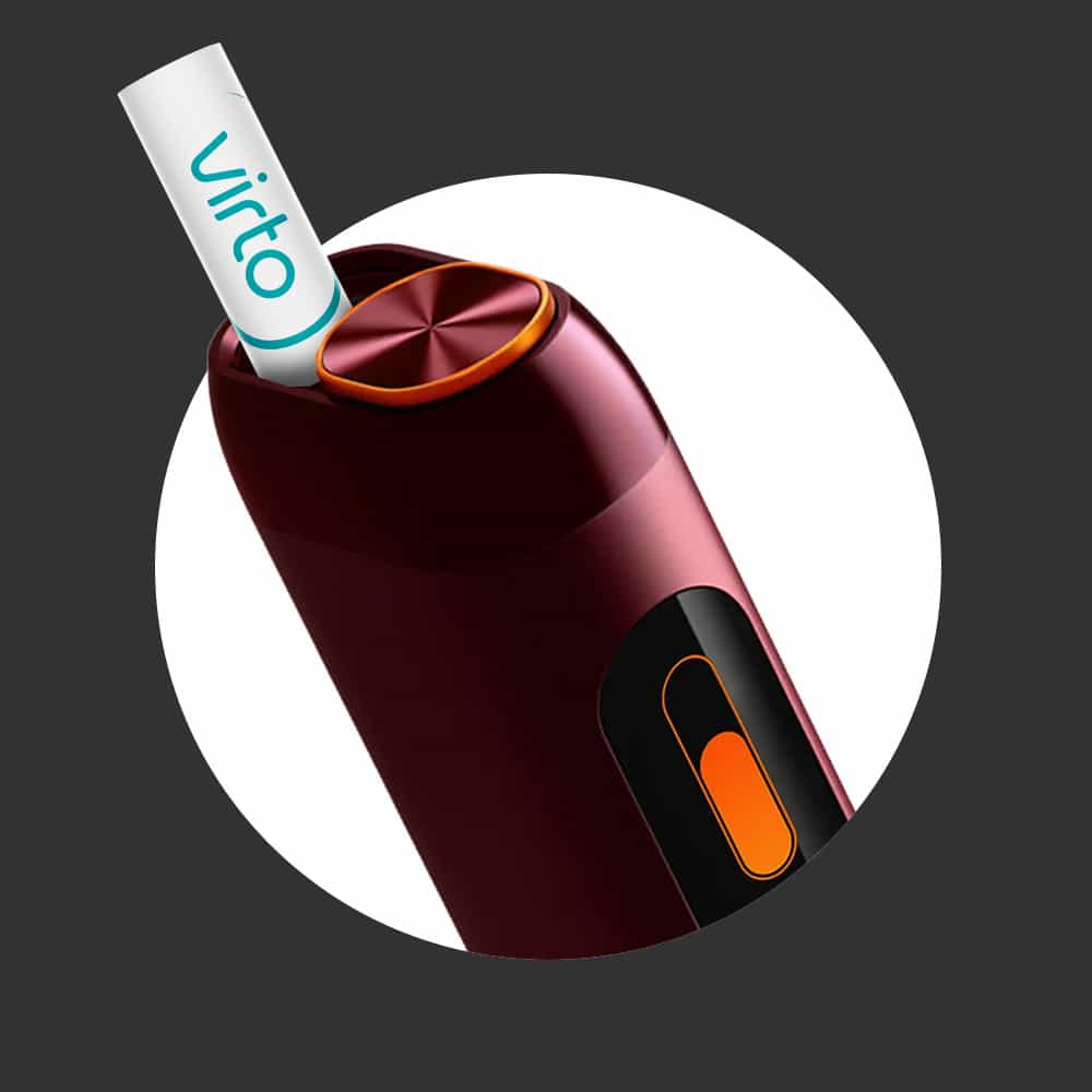 A close-up of a maroon electronic device with an orange button and a small white tube labeled Virto inserted at the top, set against a dark gray background with a white circle.