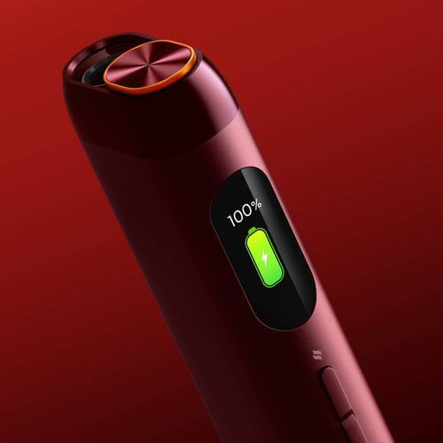 A close-up of a sleek, red electronic device with a circular top and a display screen showing a green battery icon at 100% charge, against a red gradient background.